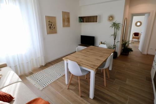 een woonkamer met een houten tafel en stoelen bij Valtellina Vacanze in Sondrio