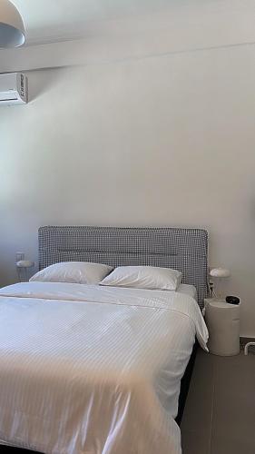 a bedroom with a large bed with white sheets at no.21house studio apartment in Rio