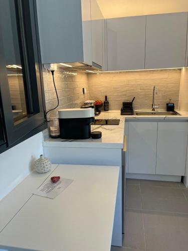 a kitchen with white cabinets and a sink at no.21house studio apartment in Rio