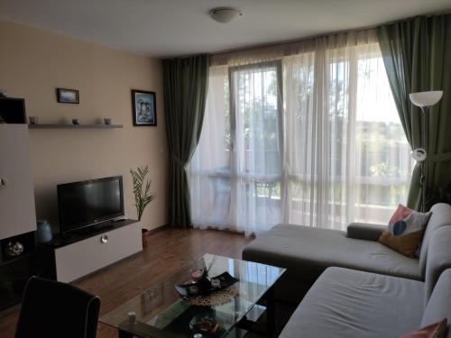ein Wohnzimmer mit Sofa und Fernseher in der Unterkunft Apartments Atia Resort in Tschernomorez