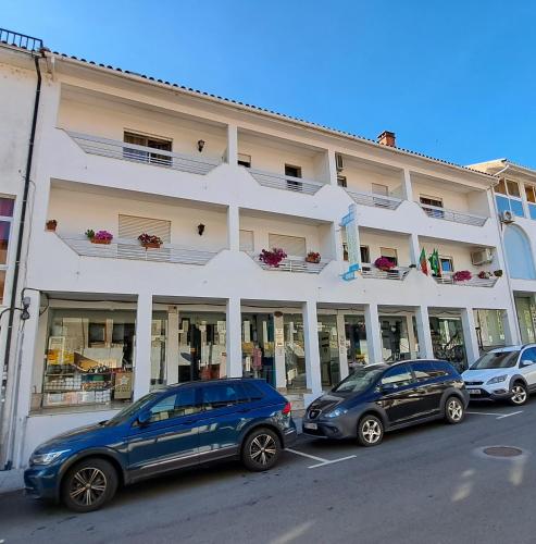 two cars parked in front of a building at Flor Do Douro - Comércio e Hotelaria, Lda in Miranda do Douro