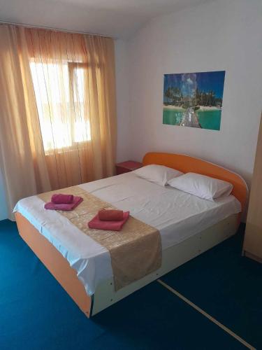 a bedroom with a bed with two towels on it at Casa Octavia in Schitul