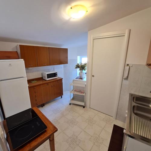 a kitchen with a white refrigerator and a table at Casa vacanza Nonno Beppe in Bagnoli del Trigno