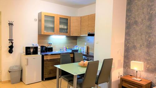 a small kitchen with a table and a refrigerator at Happy Living Apartment w Balcony in Budapest