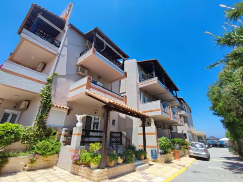 a building with balconies and plants on a street at Troulis Seaside in Amoudara Herakliou