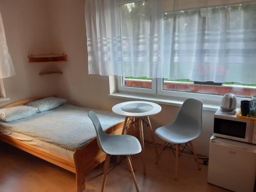 a bedroom with a bed and two chairs and a window at Joasia in Władysławowo
