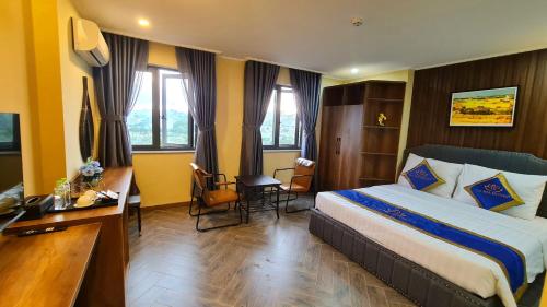 a hotel room with a bed and a desk at LA MIA Lakeview Hotel in Pleiku