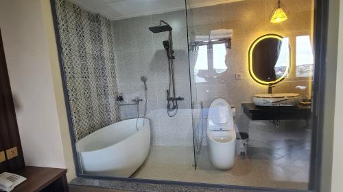 a bathroom with a tub and a toilet and a sink at LA MIA Lakeview Hotel in Pleiku