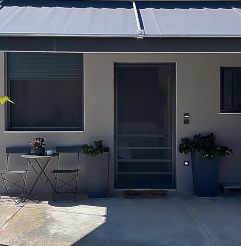 a house with a door and a table and two plants at no.21house studio apartment in Rio