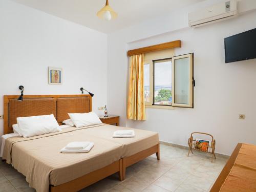 1 dormitorio con 1 cama, TV y ventana en Fotis Studios Apartments en Gouves