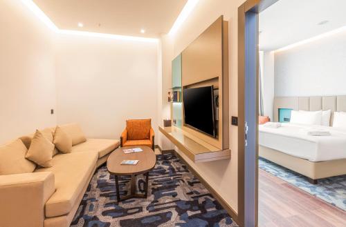 a hotel room with a couch and a bed at Wellness Park Hotel Bactria in Samarkand
