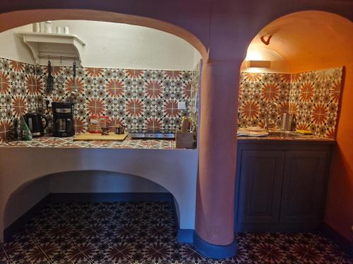 a kitchen with a counter with tiles on the wall at St.Mammas Traditional Apartment in Mesaria