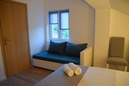 een kamer met een blauwe bank en een raam bij Apartmani Dina 2 in Posedarje
