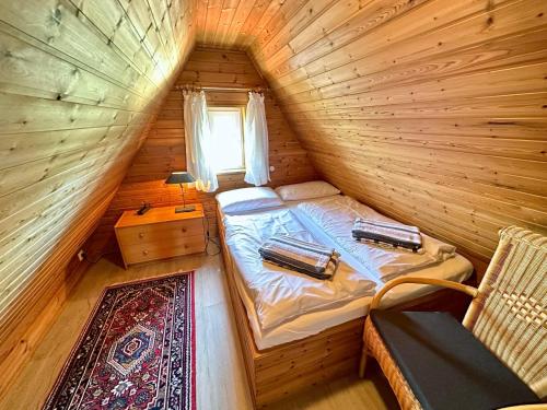 a small room with a bed in a log cabin at Haus-Inken-Maria-West in Westerland