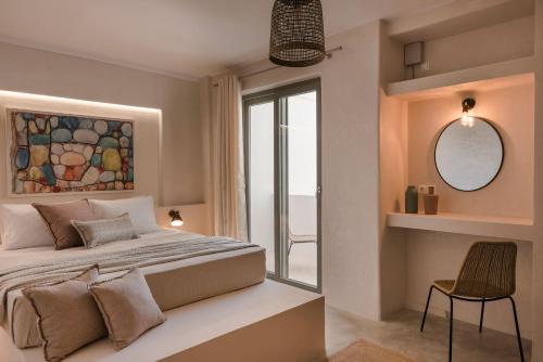 a bedroom with a bed with a window and a mirror at Villa Mirto - Iris sunset villas in Lépedha