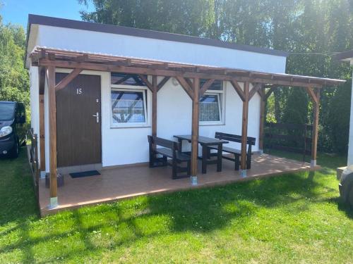 a gazebo with a table and benches on a yard at Ośrodek Wypoczynkowy Ostoja in Dźwirzyno