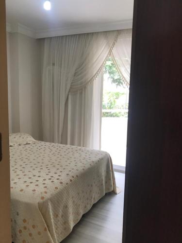 - une chambre avec un lit et une grande fenêtre dans l'établissement Denize 5 dakika, à Alanya