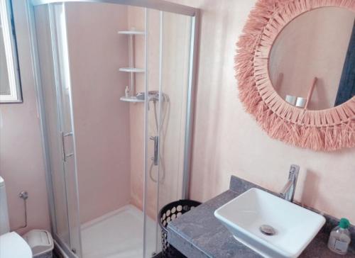 bagno con doccia, lavandino e specchio di Appartement luxueux et moderne à sidi Rehal a Dar Hamida