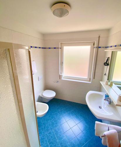 ein Bad mit 2 Waschbecken, einem WC und einem Fenster in der Unterkunft Haus Ploner in Kastelruth