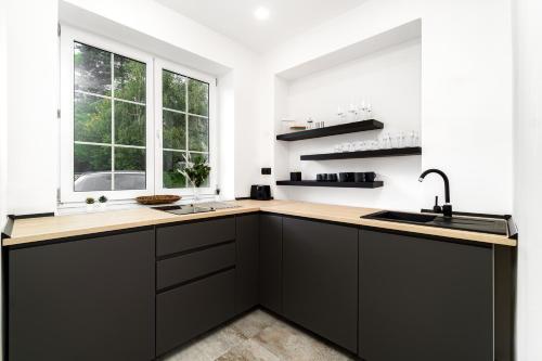 a kitchen with black cabinets and a window at Beautiful Apartments With Parking In a Quiet Location in Ostrava