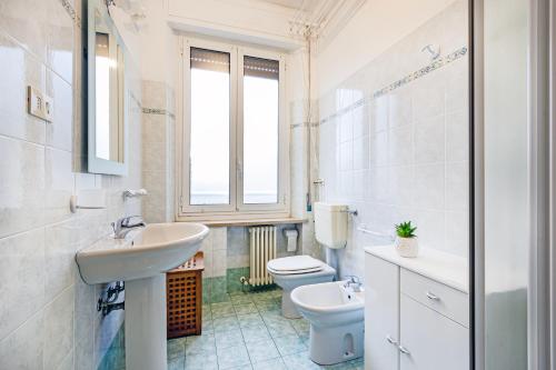 a bathroom with a sink and a toilet and a window at Shakira Apartments in Parma