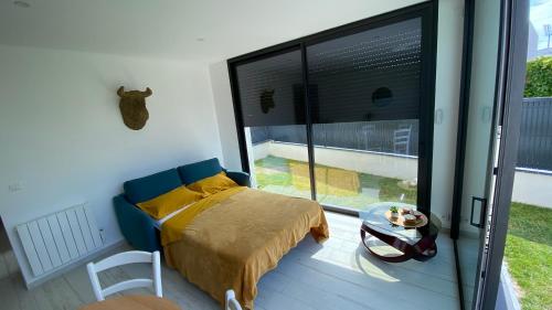 a bedroom with a bed and a large window at Soir d'Été in Royan