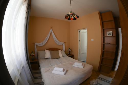 a bedroom with a bed with two towels on it at Kozmáry Vendégház in Matrafured