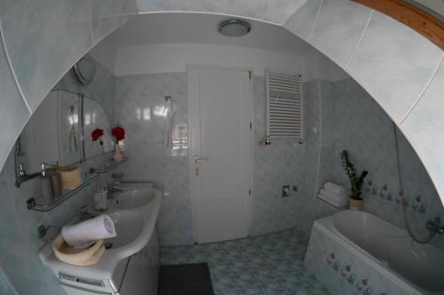 a bathroom with a white tub and a sink and a shower at Kozmáry Vendégház in Matrafured