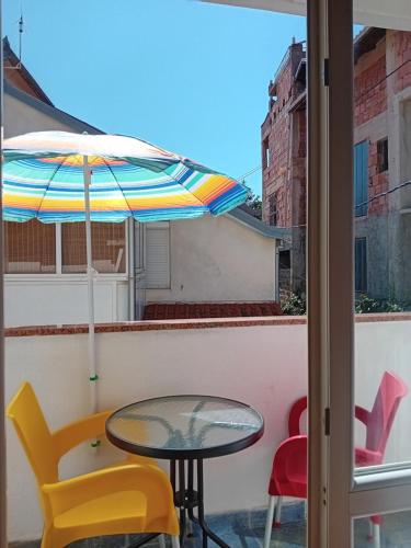 a table and chairs on a balcony with an umbrella at Vila Centar in Trebinje