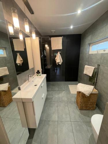 a bathroom with a white sink and a shower at Sentralt beliggende moderne leilighet in Mosjøen