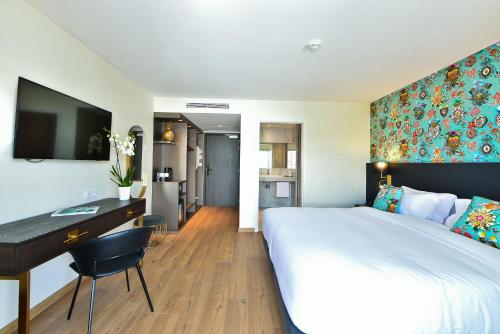 a hotel room with a large bed and a desk at Hôtel La Villa Port d'Antibes & Spa in Antibes