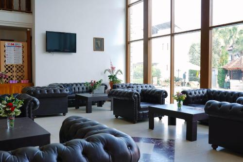 una sala de espera con sofás, mesas y TV en Felice Hotel, en Kemer