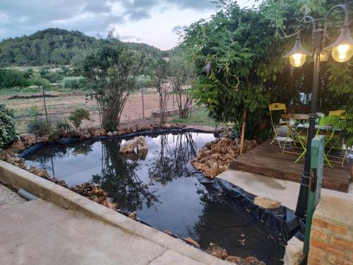 a pond in a backyard with a table and chairs at chambre d'hôtes de Lamy 1 in Pierrerue