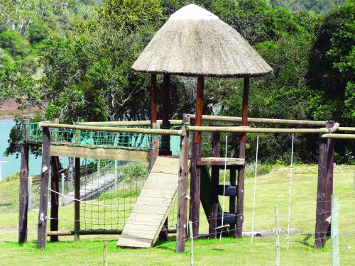 a wooden playground with a swing and a roof at Mansfield Private Reserve in Port Alfred