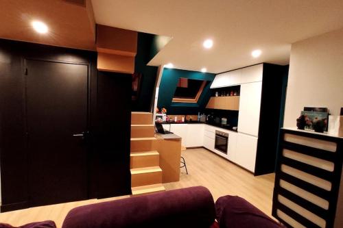 - un salon avec une cuisine dotée de placards blancs et d'un canapé dans l'établissement Le Duplex, Vue Mer et Port, à Saint-Valery-en-Caux