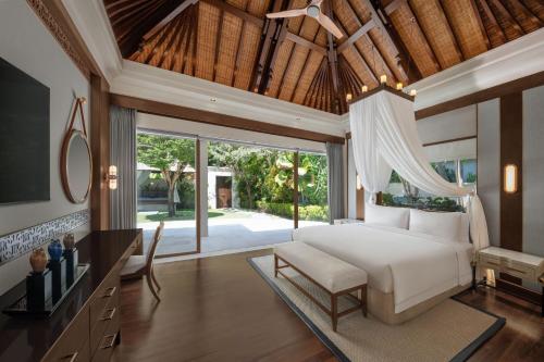 a bedroom with a white bed and a desk at The Laguna, A Luxury Collection Resort & Spa, Nusa Dua, Bali in Nusa Dua