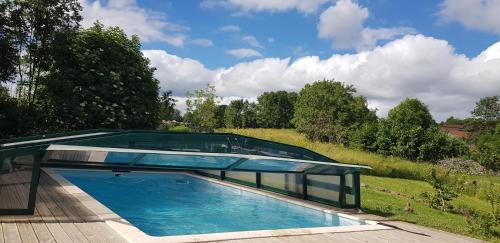 une piscine avec un toit en verre dans l'établissement Gîte familial en pleine nature, à Alleyrac