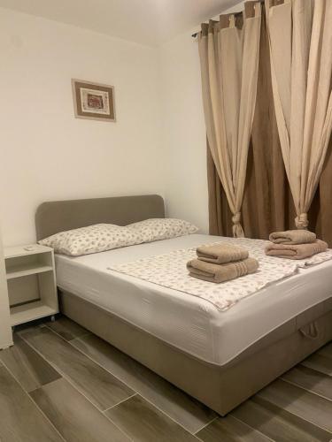 a bedroom with a bed with towels on it at Apartments Simoneta in Malinska