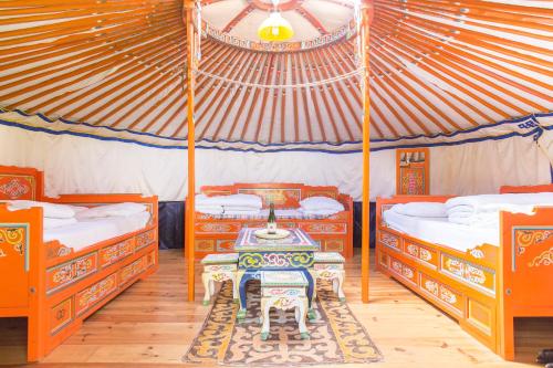 - une chambre avec 2 lits et une table dans une tente dans l'établissement Rando-Yourte, à Paluel
