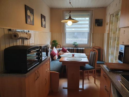 eine Küche mit einem Tisch und ein Wohnzimmer in der Unterkunft Ferienhaus Kabitschke in Dobbrikow