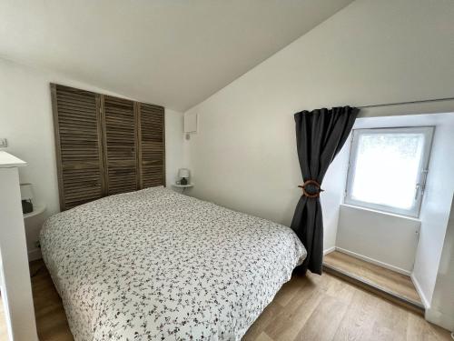 1 dormitorio con cama y ventana en Le Petit Cosy - terrasse privée, en Lagord