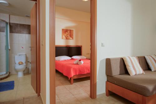 古瓦伊的住宿－Fotis Studios Apartments，一间卧室配有一张床和一张沙发,还有一间浴室