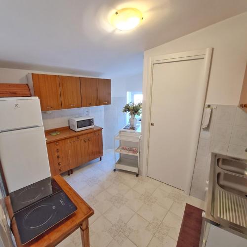 a kitchen with a white refrigerator and a table at Casa vacanza Nonno Beppe in Bagnoli del Trigno