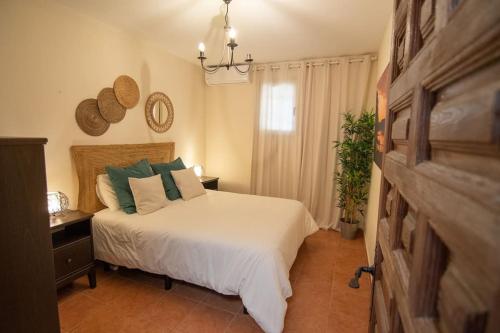 a bedroom with a white bed with green pillows at Casa del fuego in Moya