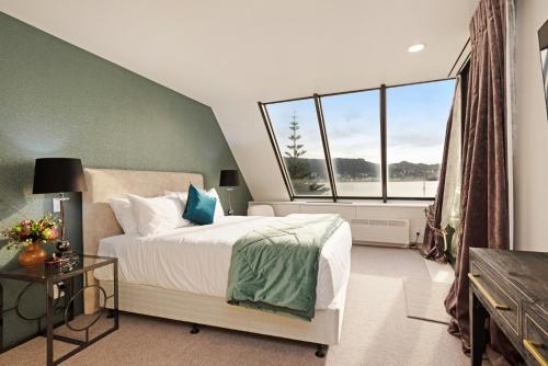a bedroom with a bed and a large window at Bay Suites - 328 Oriental Parade Wellington in Wellington