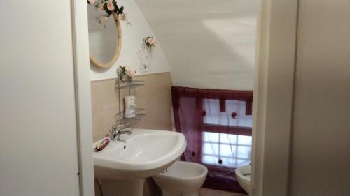 a bathroom with a sink and a toilet and a mirror at Affittacamere il Labirinto in Bisceglie