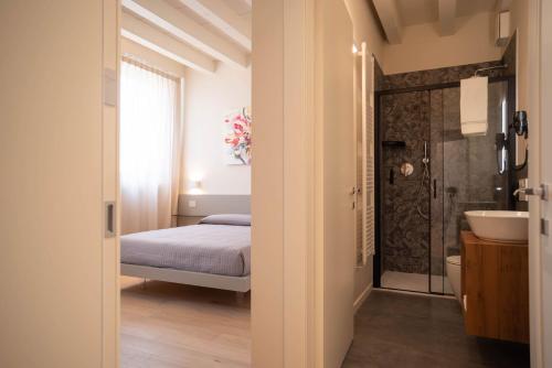 a bedroom with a bed and a bathroom with a sink at Maison Calcirelli rooms in Verona