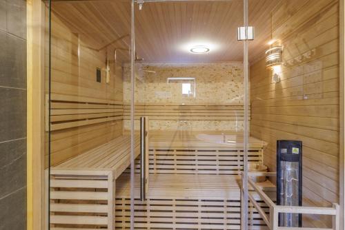 a sauna with a tub in a room with wooden walls at Rabasův Mlýn in Kožlany
