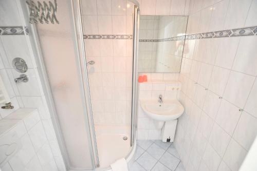 ein Bad mit einer Dusche, einem Waschbecken und einem WC in der Unterkunft Appartement 156 in Westerland