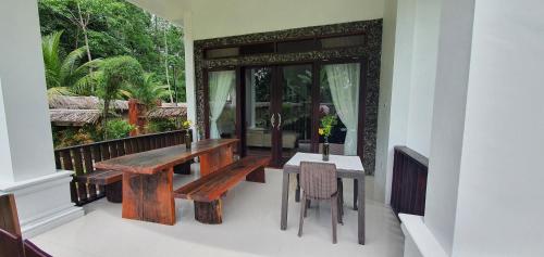 a wooden table and chairs on a balcony at Sumatra Cheeky Monkeys Villa, Trekking and Tours in Bukit Lawang